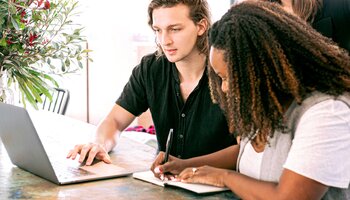 Young couple with computer and pad paper